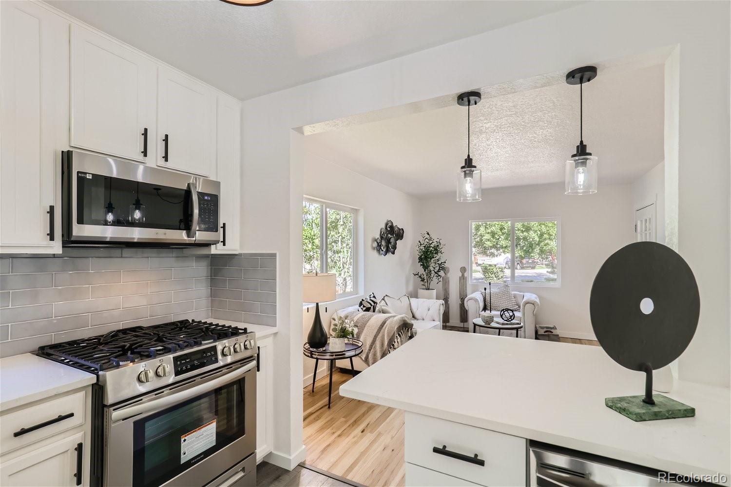 3090 Pierce Street Wheat Ridge, CO 80214 - Photo 12 of 28 a kitchen with a stove a microwave and cabinets