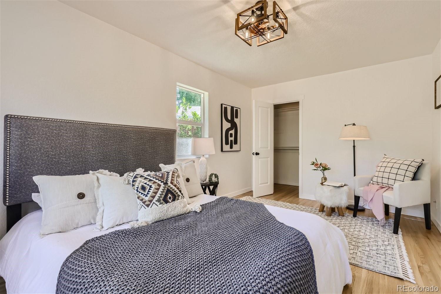 3090 Pierce Street Wheat Ridge, CO 80214 - Photo 16 of 28 a bedroom with a large bed and a chandelier