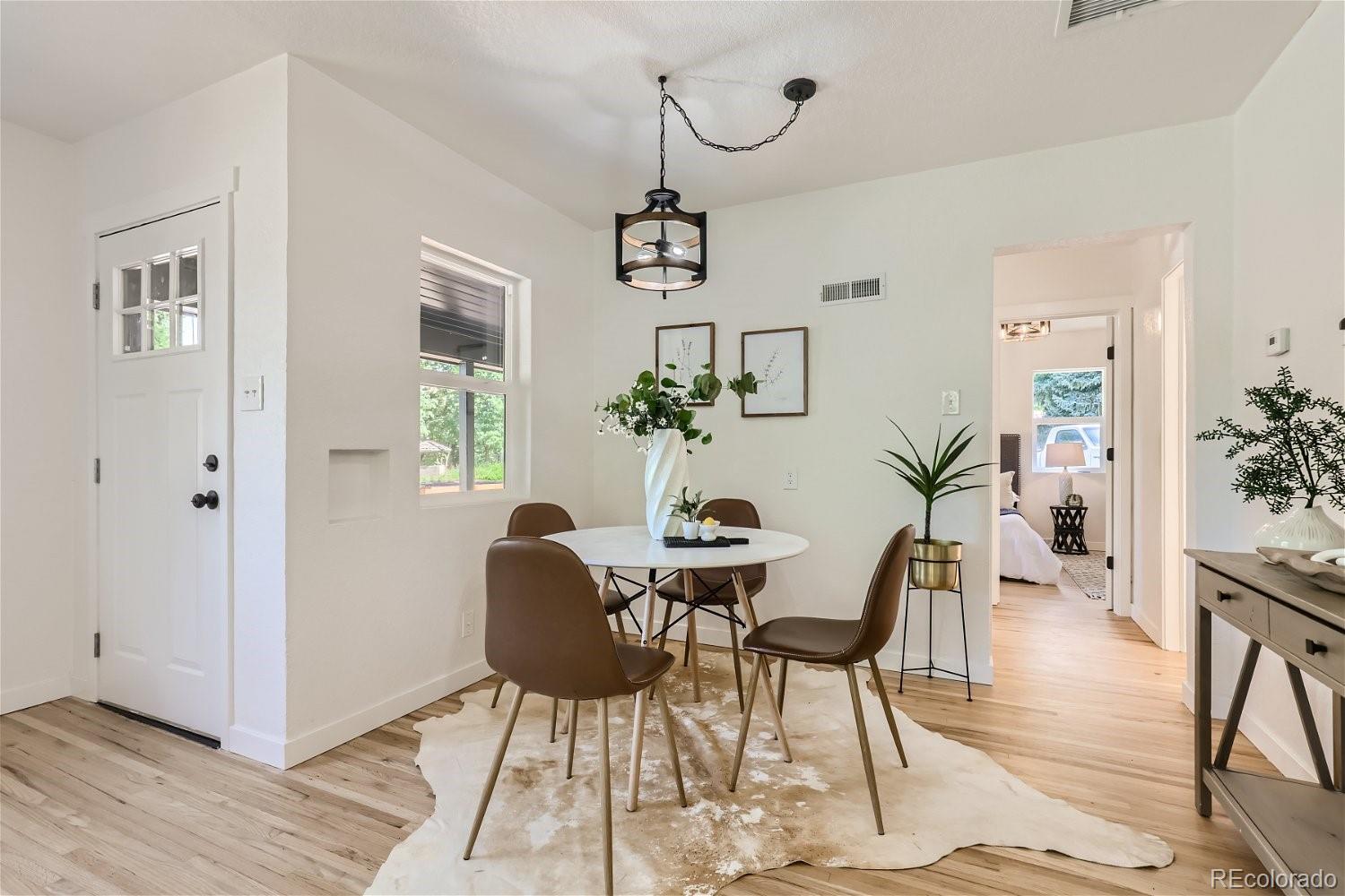 3090 Pierce Street Wheat Ridge, CO 80214 - Photo 5 of 28 a dining room with wooden floor a glass table and chairs