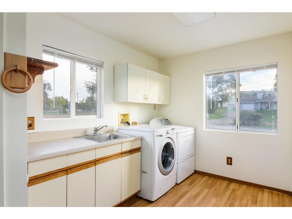 14803 Fruitvale Road Valley Center, CA 92082 - Photo 15 of 25 Laundry Room has several cupboards, utility sink, washer & dryer and refrigerator.
