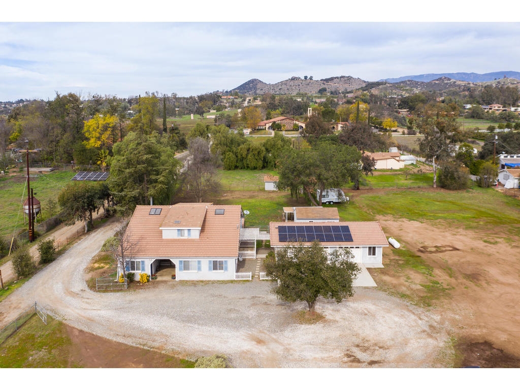 14803 Fruitvale Road Valley Center, CA 92082 - Photo 23 of 25 Main home and 3 Car Garage with solar. Workshop Building just beyond home. Irrigation Well House further back.