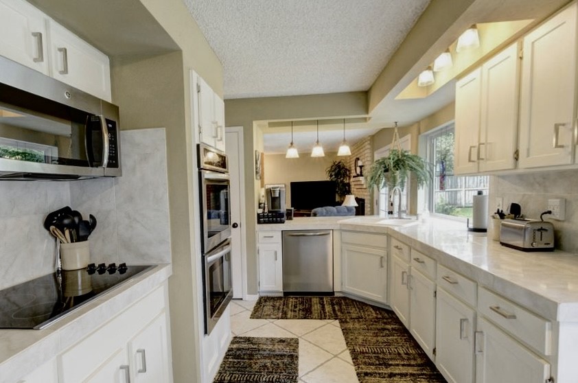 11719 Cedar Form Lane Meadows Place, TX 77477 - Photo 13 of 39 a kitchen with a sink stainless steel appliances and cabinets
