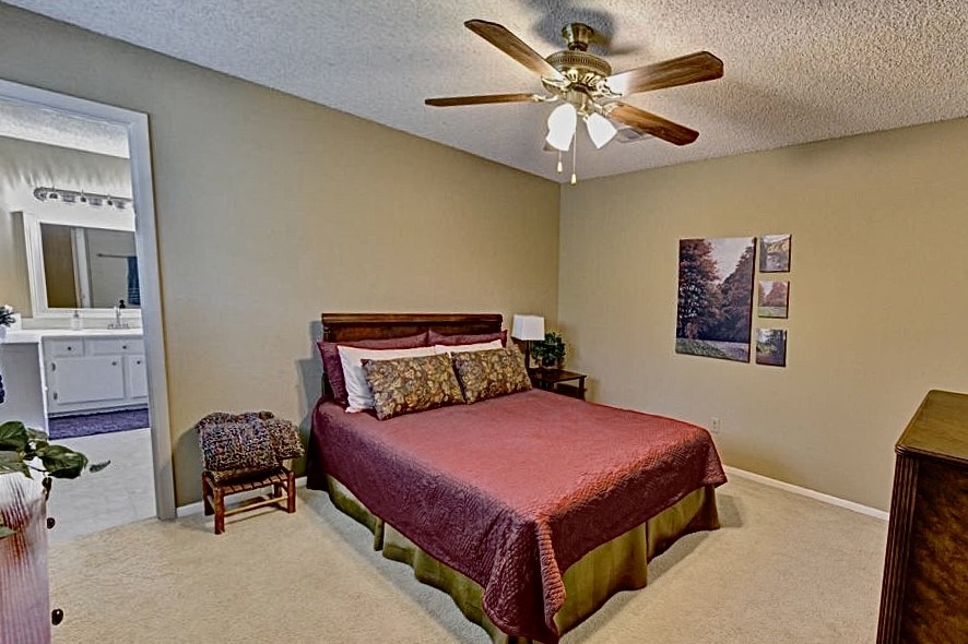 11719 Cedar Form Lane Meadows Place, TX 77477 - Photo 26 of 39 a bedroom with a bed and a chandelier