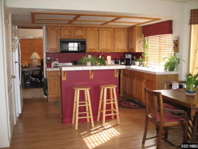 5920 Simons Drive Reno, NV 89523 - Photo 5 of 8 a kitchen with stainless steel appliances granite countertop a table chairs and a refrigerator