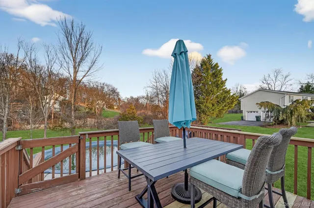 a view of a deck with table and chairs with wooden floor and fence
