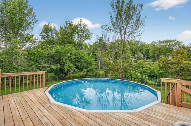 a view of backyard with swimming pool and furniture