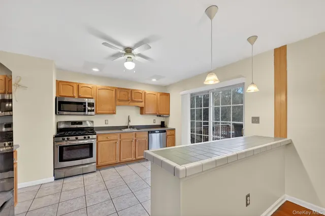 a kitchen with kitchen island granite countertop a stove a sink and a refrigerator