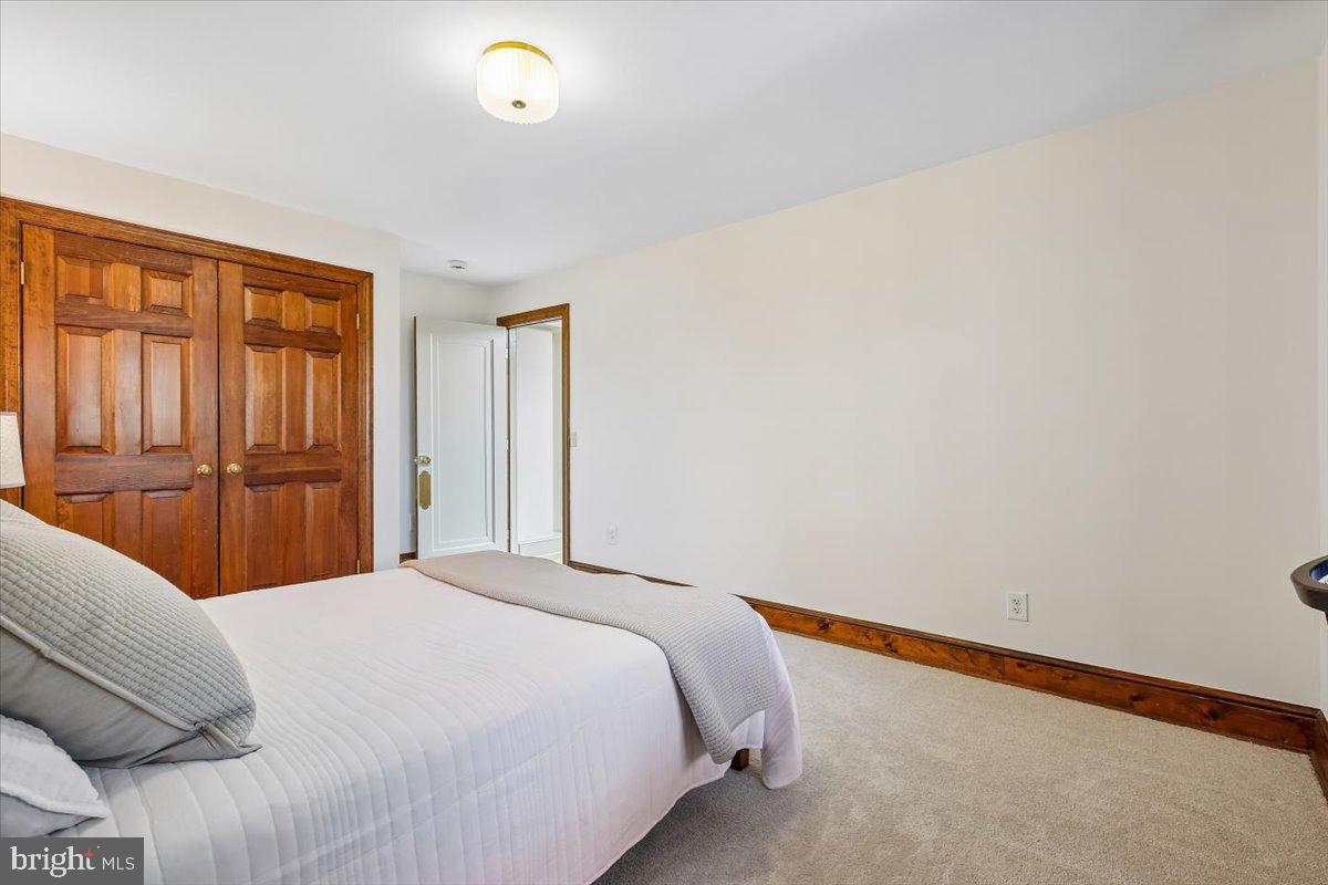 6317 Poe Road Bethesda, MD 20817 - Photo 24 of 43 a bedroom with a bed and a lamp with wooden floor