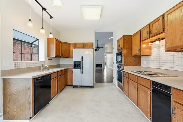 a kitchen with stainless steel appliances granite countertop a stove a sink dishwasher a refrigerator and cabinets with wooden floor