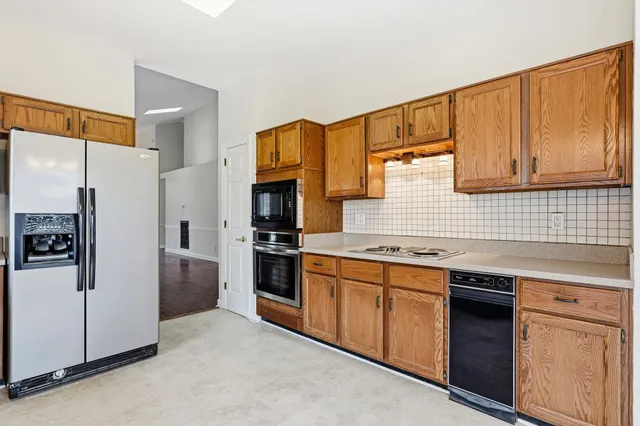 a kitchen with stainless steel appliances granite countertop a refrigerator and a stove