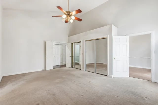 an empty room with a ceiling fan and a window