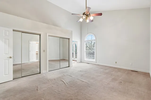 an empty room with fan and windows