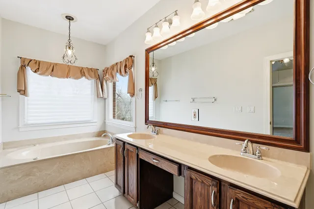 a bathroom with a granite countertop sink mirror and a bathtub