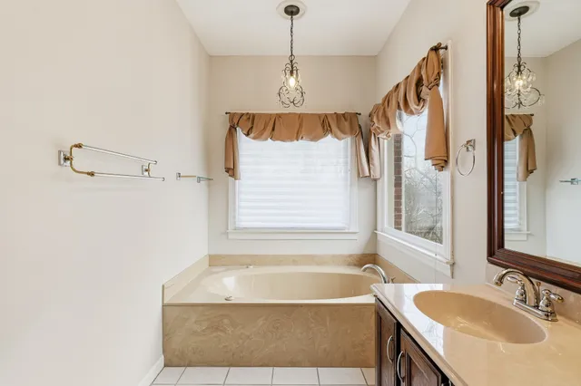a bathroom with a granite countertop sink and a bathtub