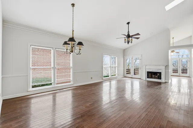 a view of empty room with wooden floor fireplace and windows