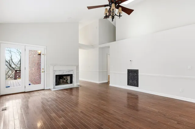 a view of empty room with wooden floor and fireplace