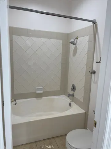 a white bath tub sitting next to a white toilet and sink