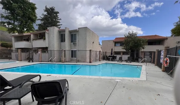 a view of a house with pool and chairs
