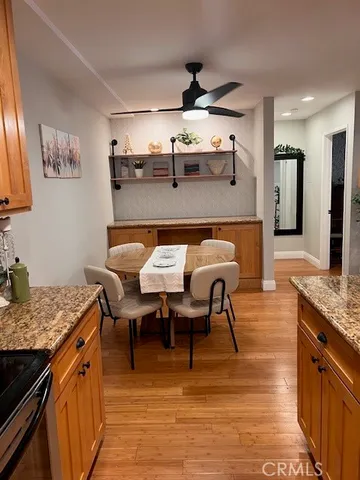a dining hall with stainless steel appliances granite countertop a stove top oven a sink and dishwasher
