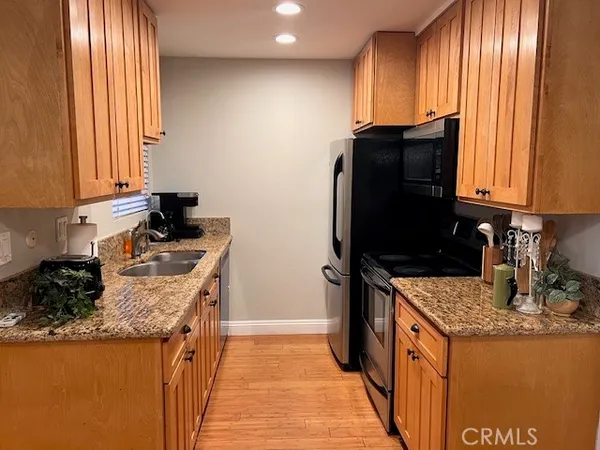 a kitchen with granite countertop a sink stove and refrigerator