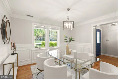 a view of a dining room with furniture a kitchen and chandelier