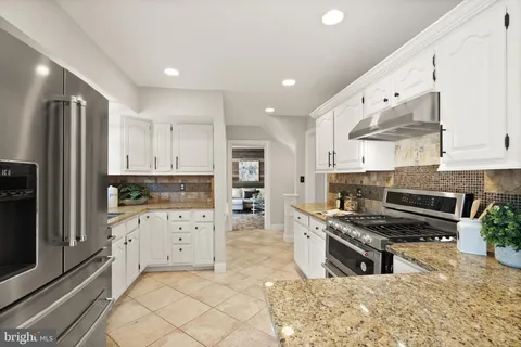 a kitchen with white cabinets and appliances