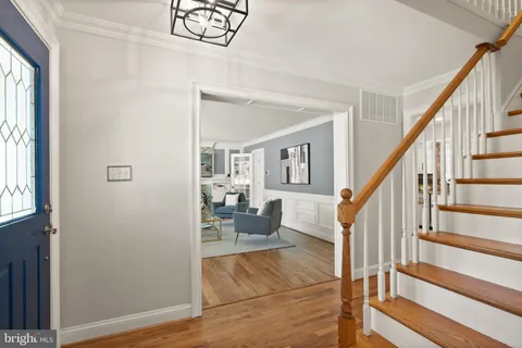 a living room with furniture a fireplace and a dining table with wooden floor