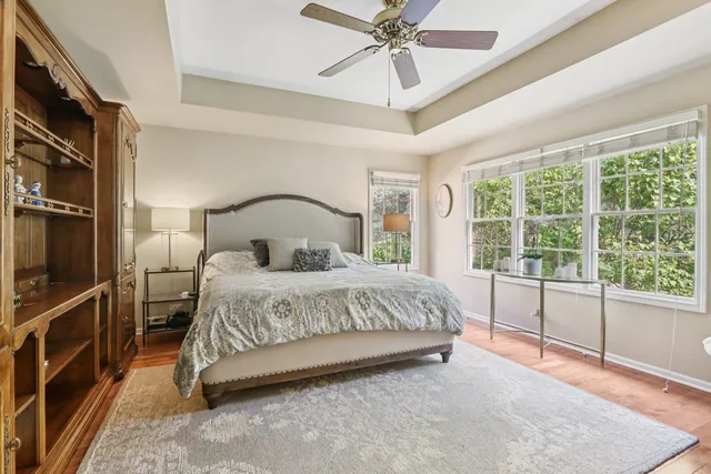 a bedroom with a large bed and a chandelier fan