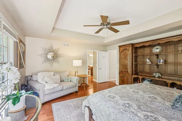 a bedroom with a bed a couch and a large window