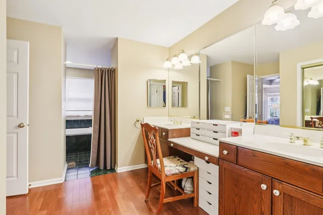 a view of a bathroom with a sink mirror and wooden floor