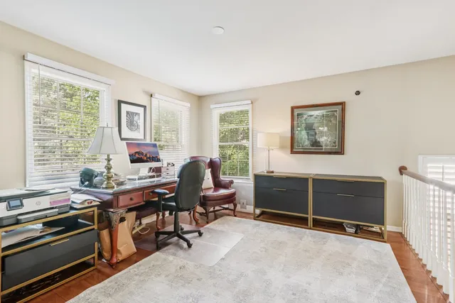 a view of a workspace with furniture and a window