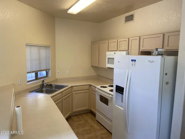 a kitchen that has a sink a refrigerator and a sink