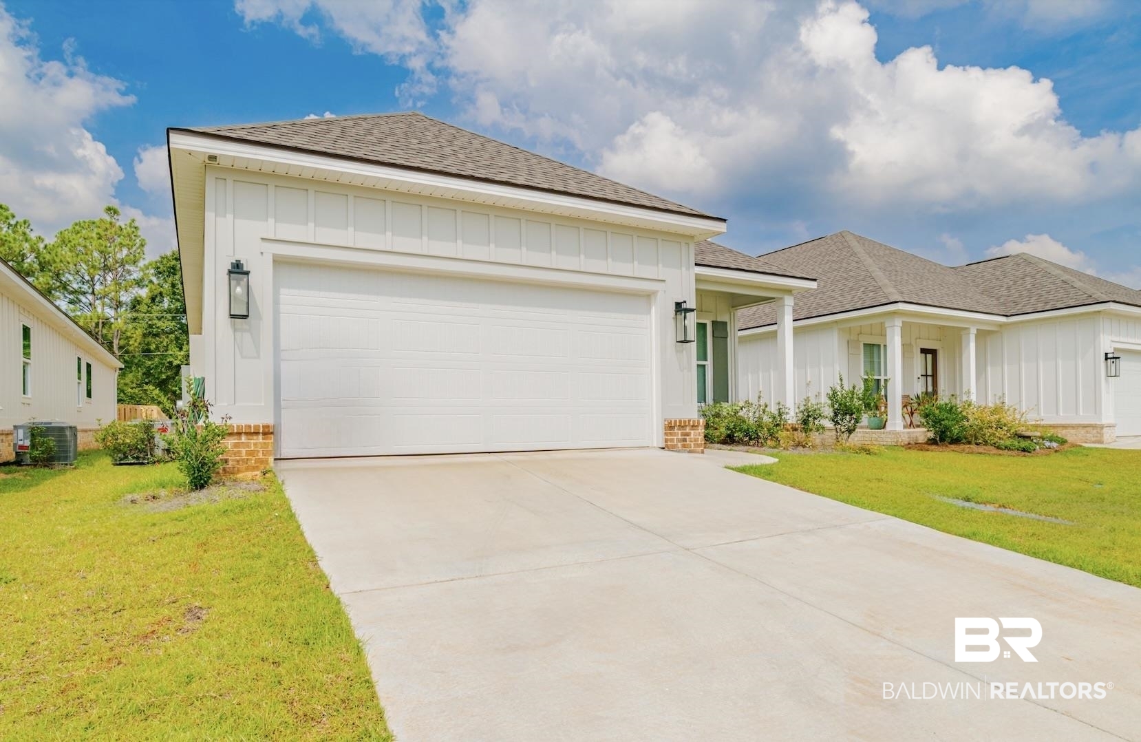 655 H Norman Lane Fairhope, AL 36532 - Photo 2 of 30 View of front facade with central AC, a front lawn, and a garage