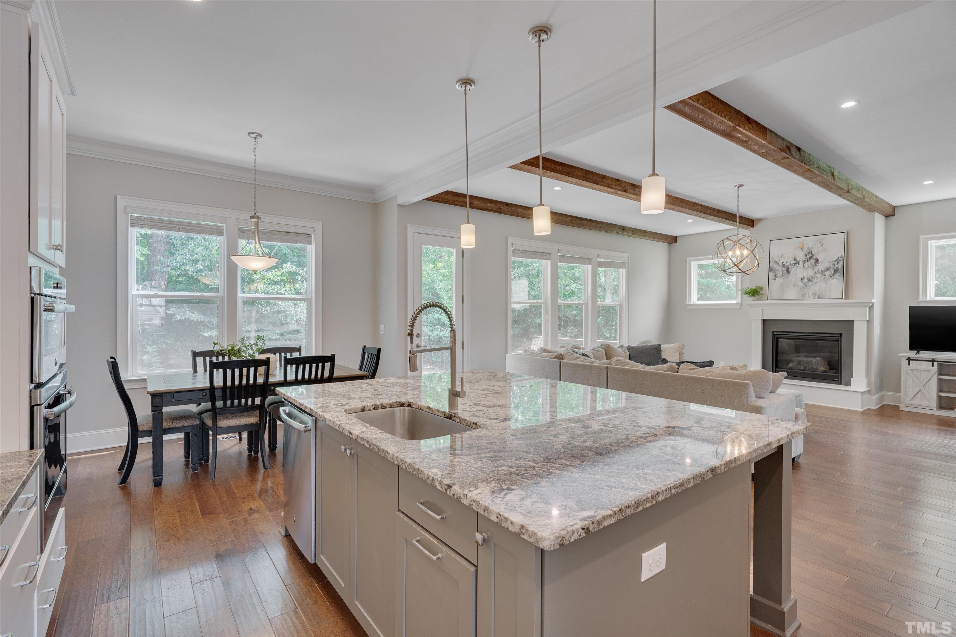 8012 Shree Court Raleigh, NC 27613 - Photo 15 of 49 a kitchen with granite countertop a table chairs stove a refrigerator and cabinets