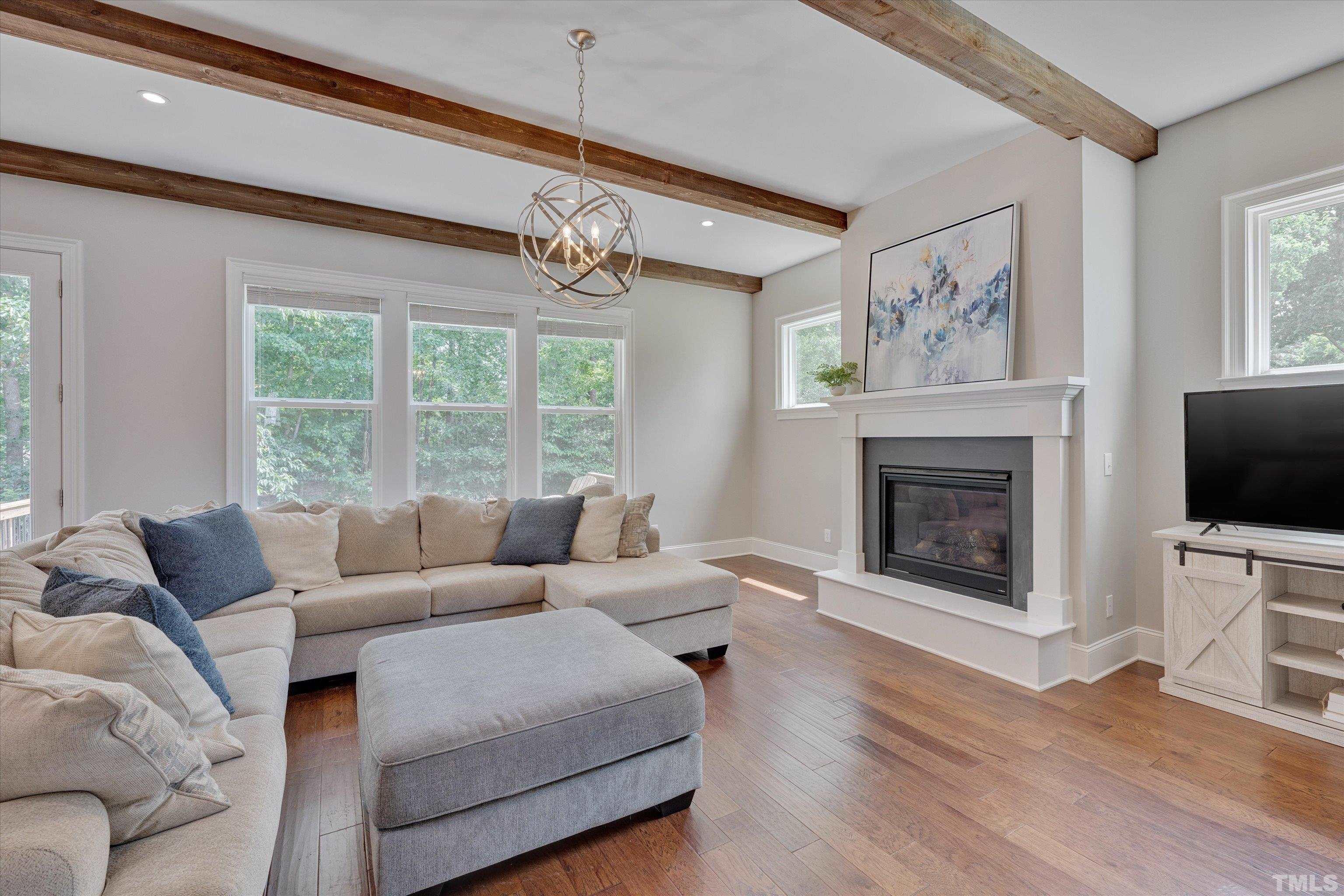 8012 Shree Court Raleigh, NC 27613 - Photo 18 of 49 a living room with furniture a flat screen tv and a fireplace