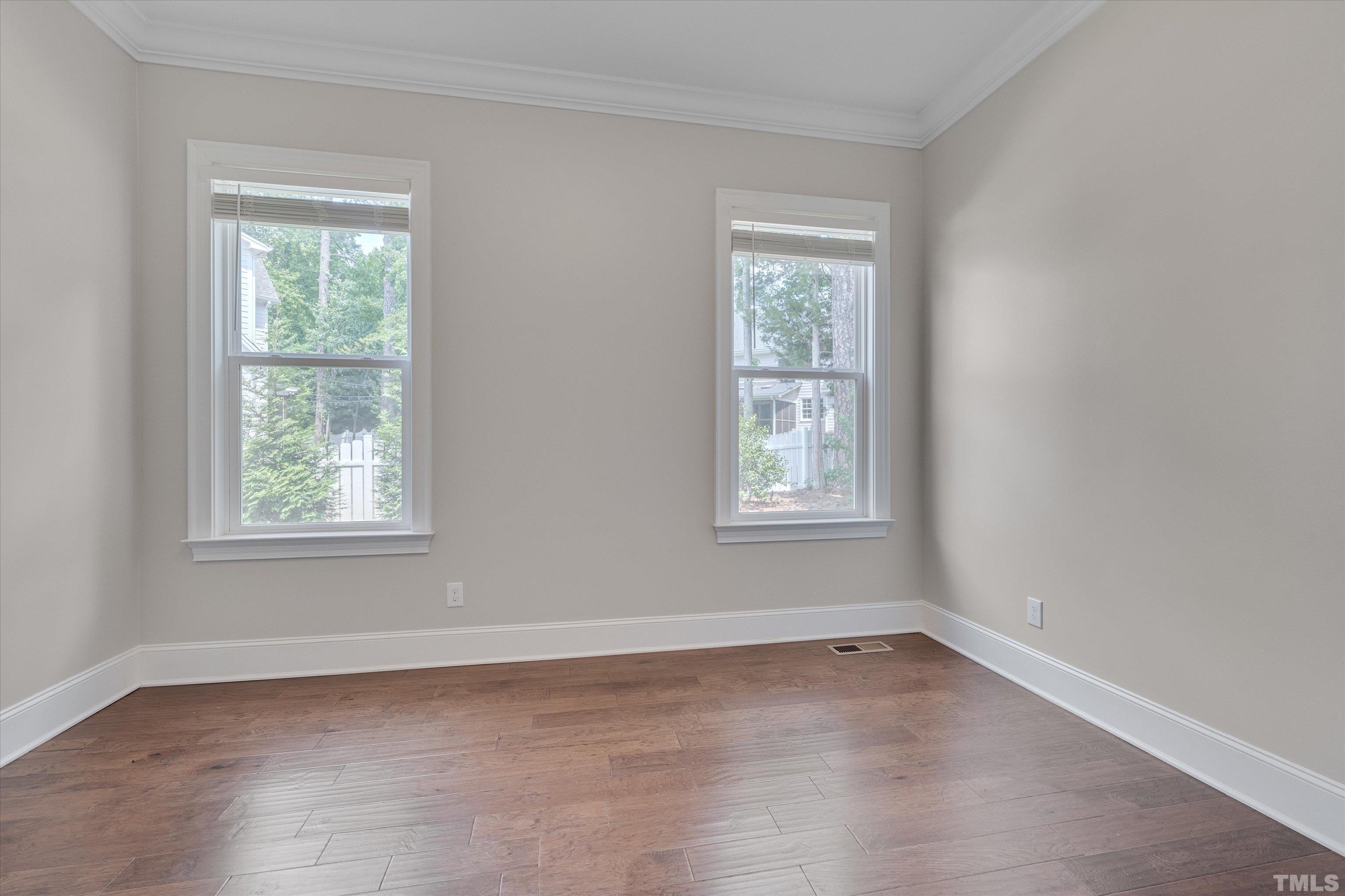 8012 Shree Court Raleigh, NC 27613 - Photo 26 of 49 a view of an empty room with wooden floor and a window