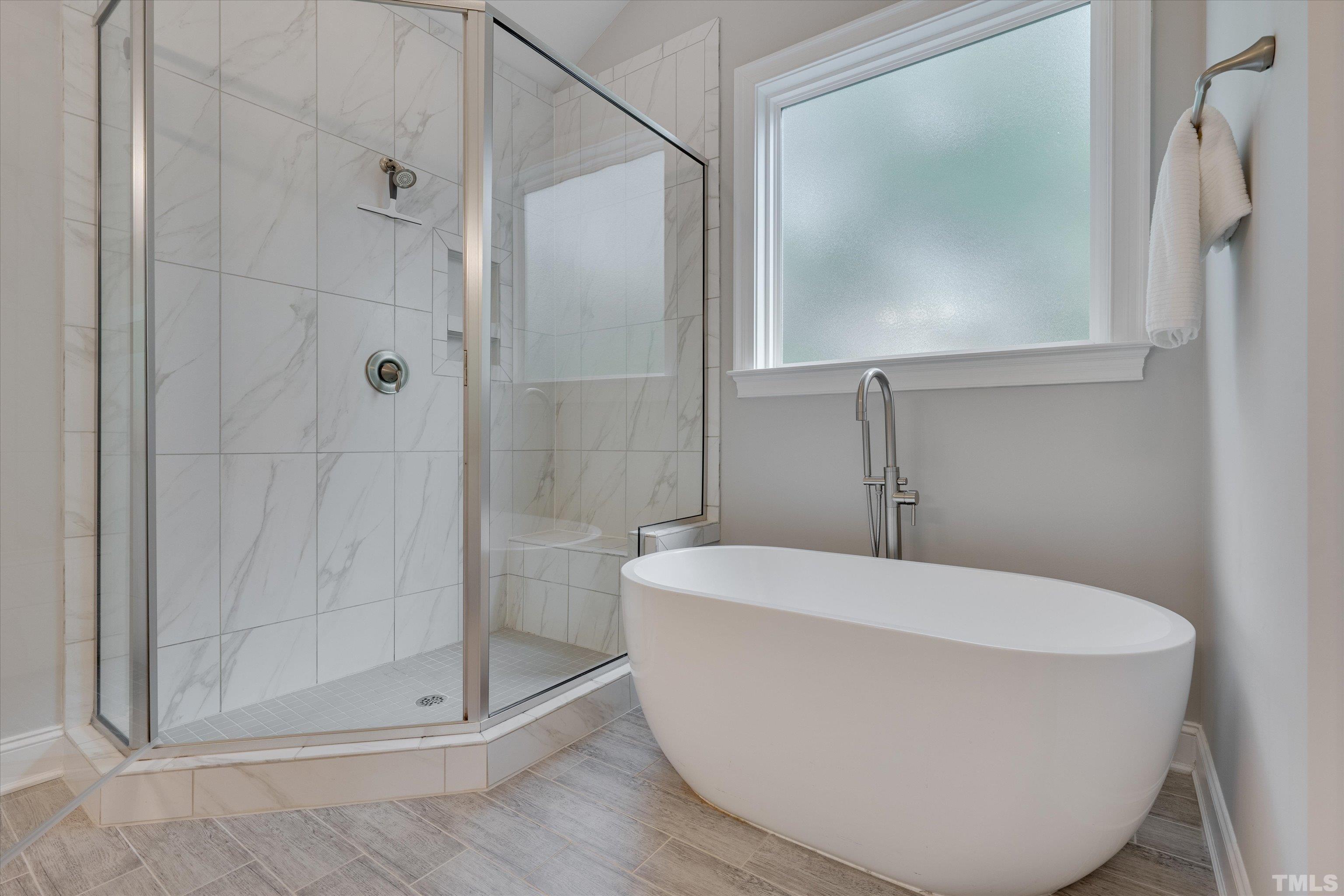 8012 Shree Court Raleigh, NC 27613 - Photo 30 of 49 a white bath tub sitting next to a white sink and a mirror