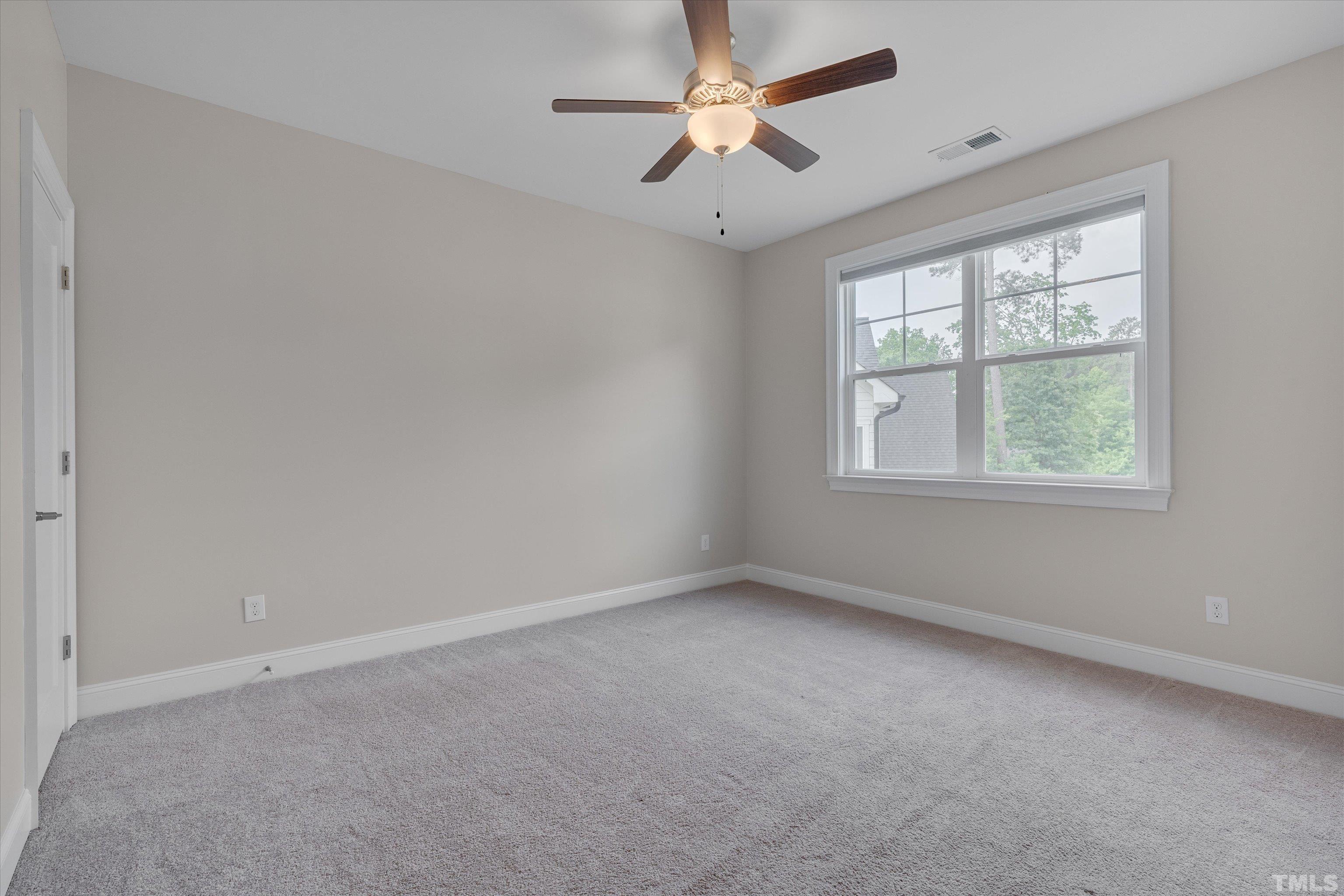 8012 Shree Court Raleigh, NC 27613 - Photo 32 of 49 an empty room with a window and a fan