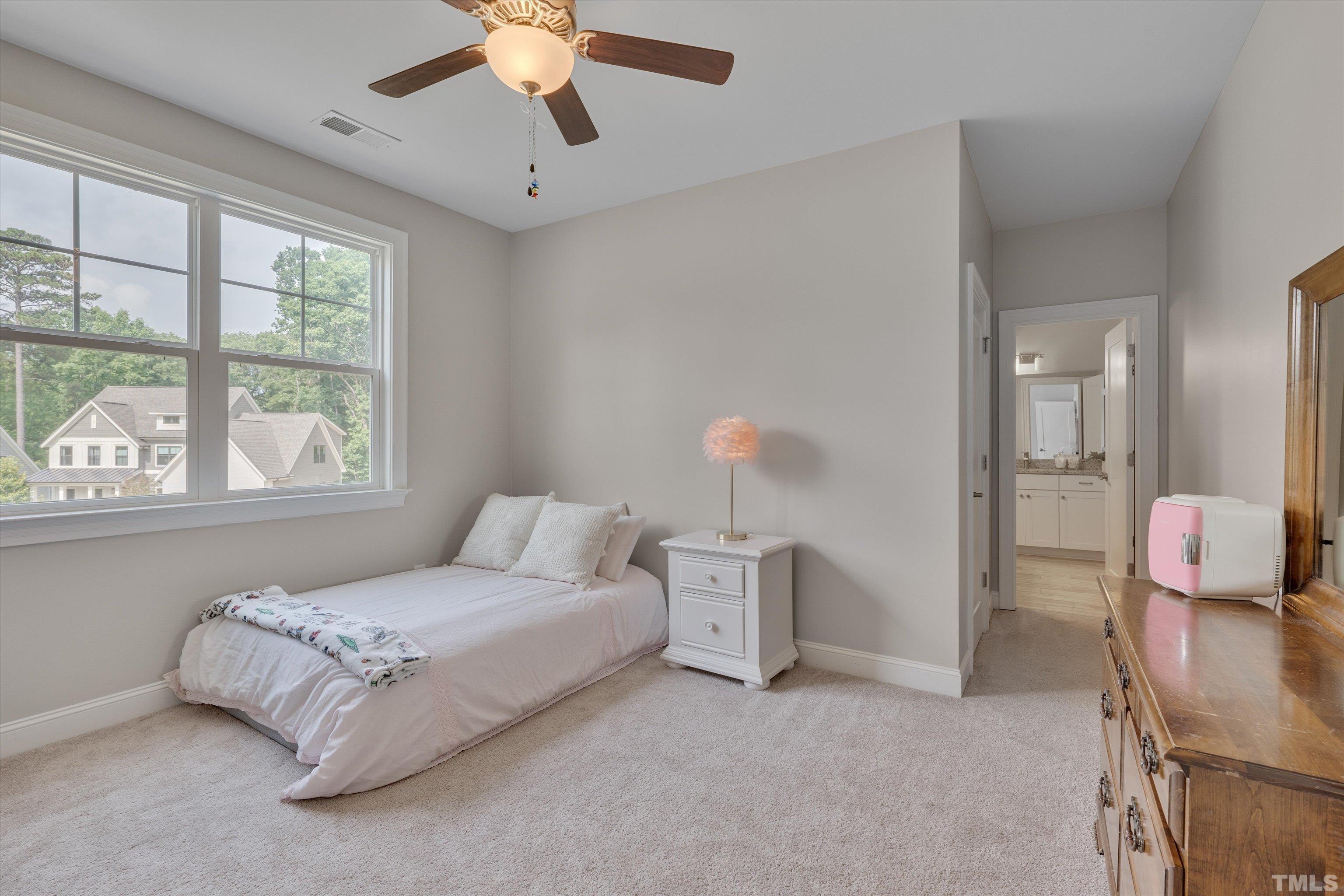 8012 Shree Court Raleigh, NC 27613 - Photo 35 of 49 a bedroom with a bed and a chandelier