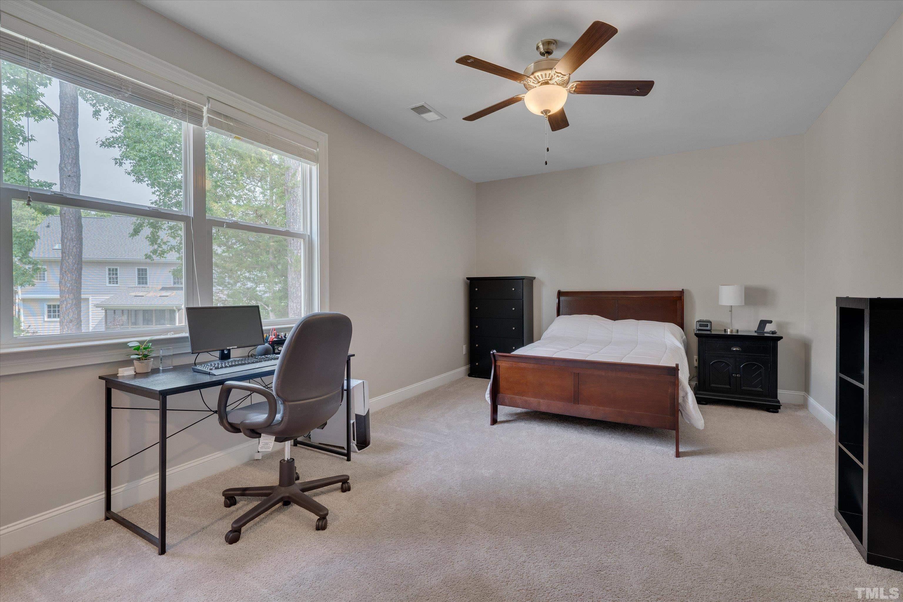8012 Shree Court Raleigh, NC 27613 - Photo 38 of 49 a bedroom with a bed a desk and a chandelier