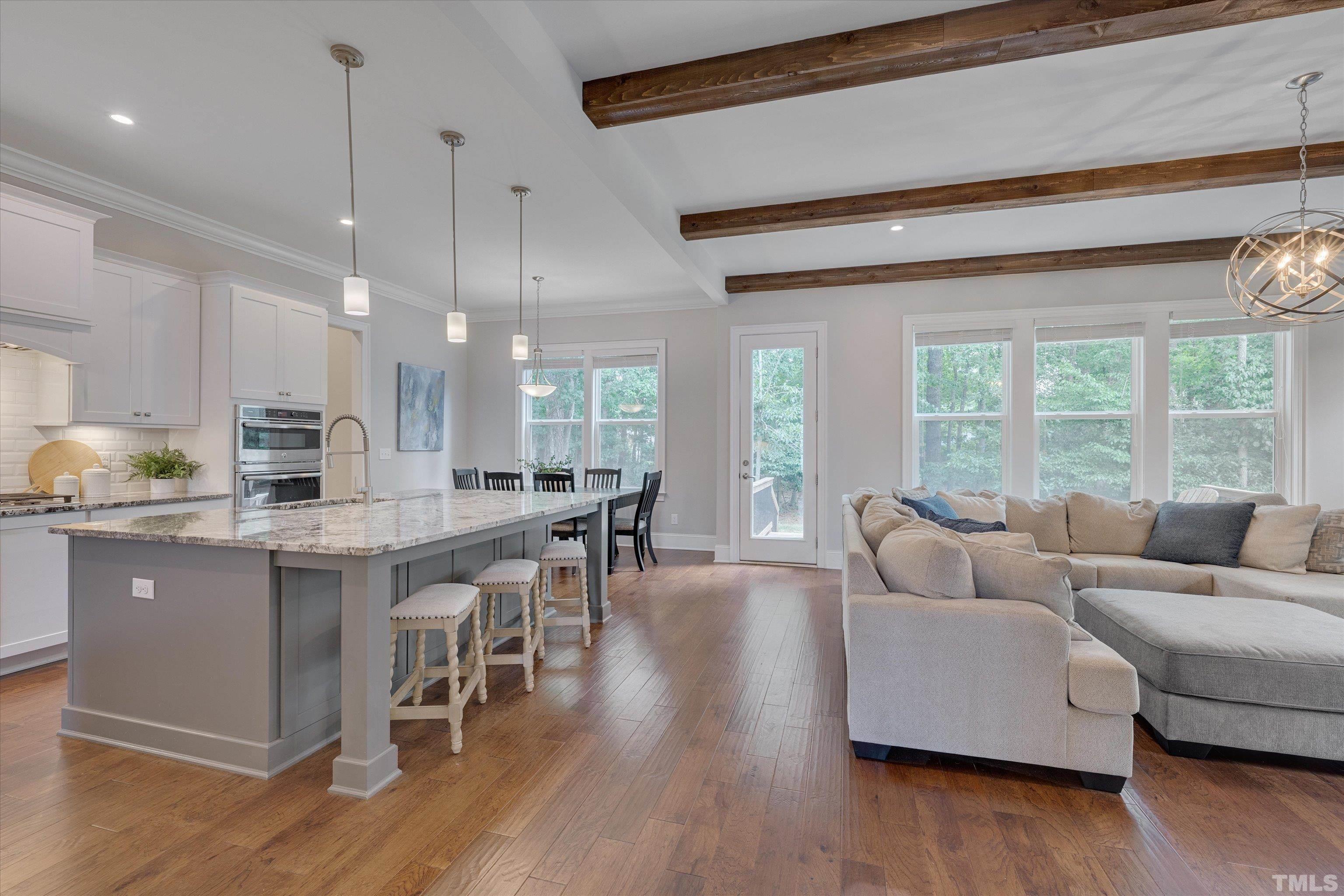 8012 Shree Court Raleigh, NC 27613 - Photo 10 of 49 a living room with furniture a wooden floor and a large window