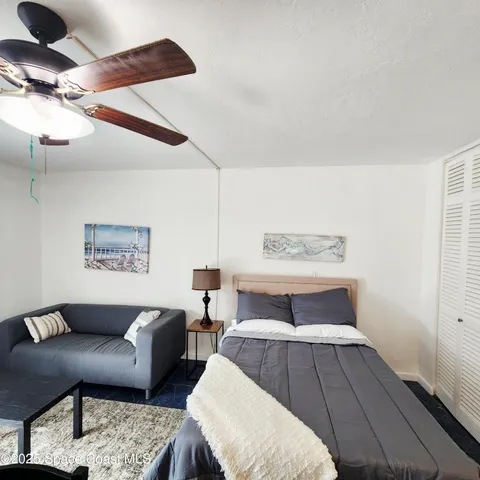 a bedroom with furniture and a ceiling fan