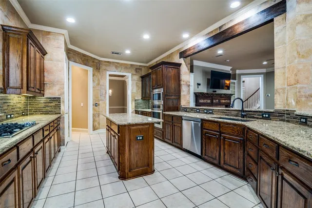 a kitchen with stainless steel appliances granite countertop a stove a sink dishwasher a refrigerator and a oven