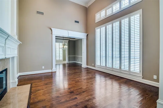 a view of empty room with wooden floor and fireplace
