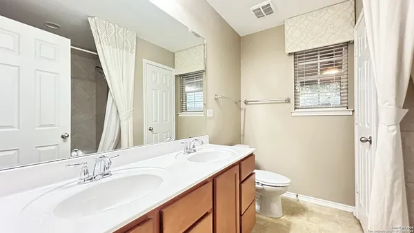 a bathroom with a sink a toilet and a mirror