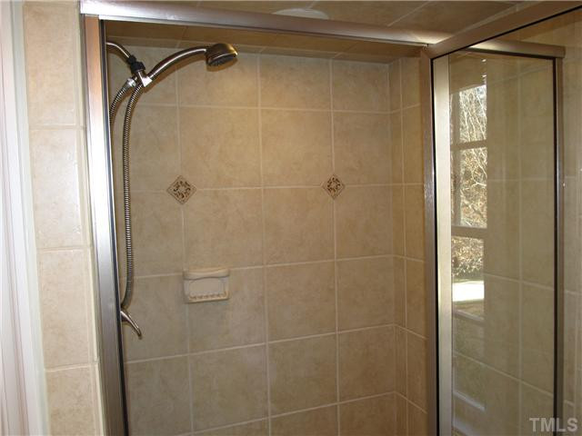 10037 Old Warden Road Raleigh, NC 27615 - Photo 17 of 25 a bathroom with a shower and a glass door