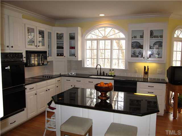 10037 Old Warden Road Raleigh, NC 27615 - Photo 9 of 25 a kitchen with a sink a stove and cabinets