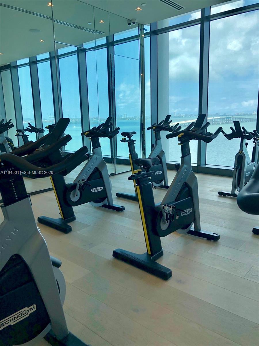 3131 Northeast 7th Avenue, Unit 3305 Miami, FL 33137 - Photo 26 of 44 a room with gym equipment and large mirror