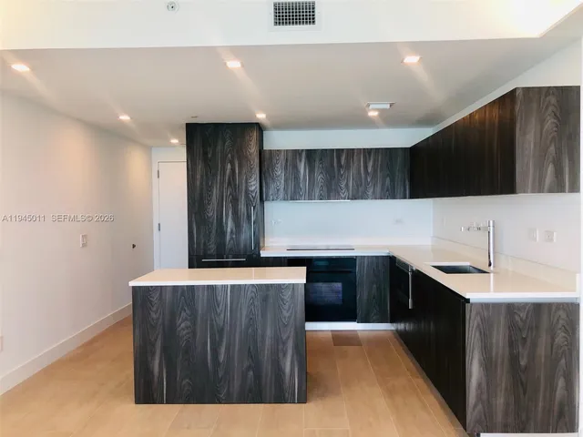 a kitchen with a sink a stove and cabinets
