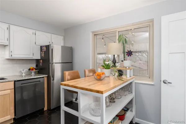 a kitchen with a refrigerator a stove and a dining table